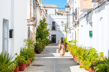a woman is walking throught a colorful street in tarifa, Spain