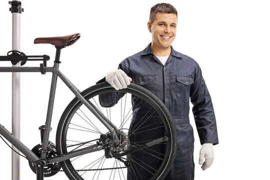 Bicycle mechanic fixing a bicycle wheel and looking at camera