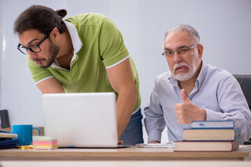 Old male teacher and young male student in the classroom