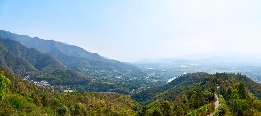 View of picturesque haze valley of the Kok River and Thai border town of Tha Ton from the hill top close to Wat Tha Ton. The Mekong tributary flows through the highlands of Northern Thailand.