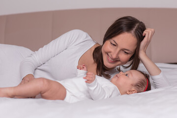 happy woman with baby lying on the bed