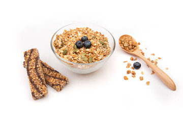 Energy granola on a clear bowl, candy bars with honey on a white background.