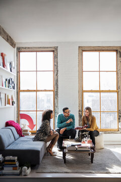 Businesswoman showing book on coworkers during discussing in office