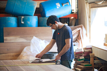 Carpenter reading documents at workshop