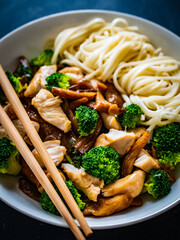 Chicken nuggets with noodles and oyster mushrooms on black table
