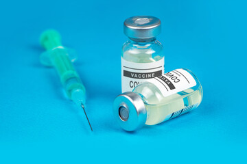 Vaccination. Syringe and vaccine COVID-19. Coronavirus on blue background