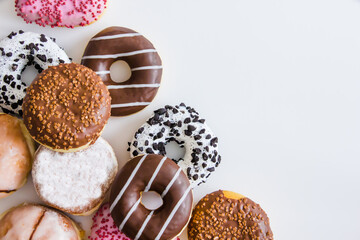 Donuts with colorful icing on a white background. Place for text.