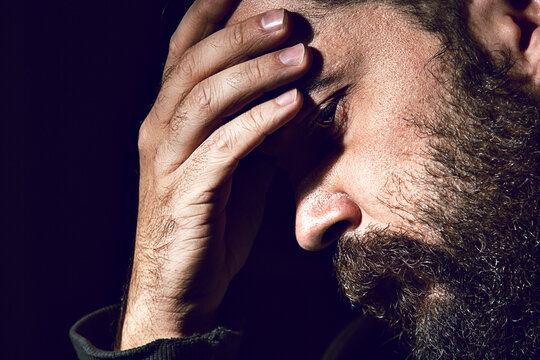Close-up of tensed man against black background