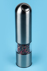 Pepper silver grinder on blue background