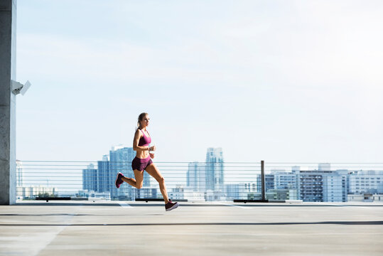 Determined female athlete running on parking lot