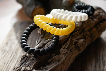 Fashionable and modern elastic hair springs. Different colors of stretching hand bracelets on wooden background, stand