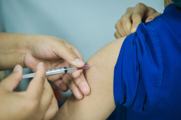 Doctor giving patient vaccine, flu or influenza shot or taking blood test with needle. Nurse with...