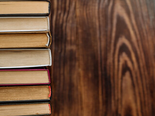 a stack of vintage reading books on a wooden background copy space