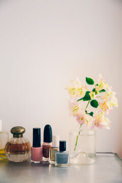 Beauty products arranged by flower vase on table