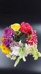 Close up. Beautiful bouquet of blooming colorful bright flowers isolated in dark background. 