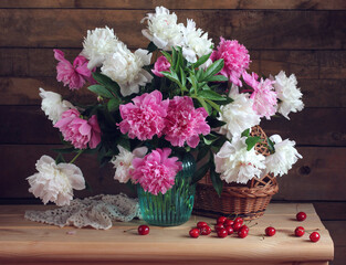 white and pink peonies in a vase on the table.