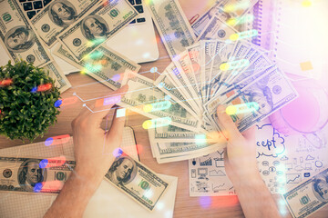 Multi exposure of technology drawing hologram and us dollars bills and man hands. Data concept