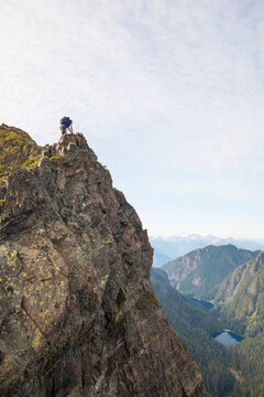 Low angle view of carefree hiker with backpack on mountain against sky
