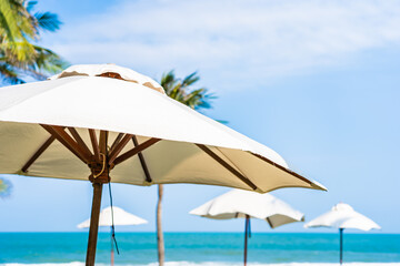 Obraz na płótnie Canvas Umbrella and chair around sea beach ocean with coconut palm tree