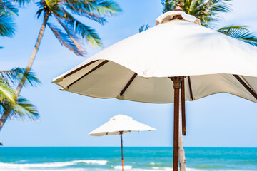 Obraz na płótnie Canvas Umbrella and chair around sea beach ocean with coconut palm tree