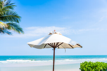 Umbrella and chair around sea beach ocean with coconut palm tree