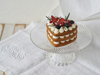 Homemade heart shaped cake with strawberries on a white napkin.