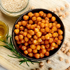 Vegan healthy snack, homemade roasted chickpeas in bowl on light gray background.