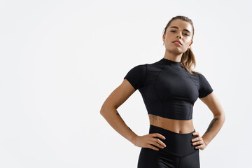 Confident healthy and athletic woman staring determined at camera, holding hands on hips....