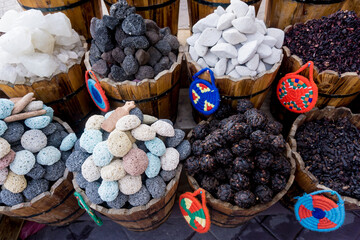Colored pumice stones for foot care in the wooden baskets on the street market