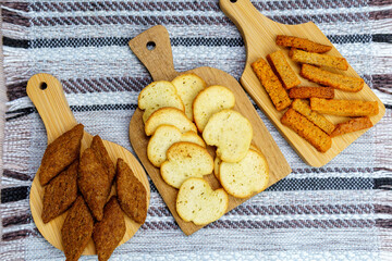 different types croutons on wooden boards close-up, white, brown, dark