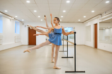 Three young ballerinas rehearsing at the barre