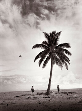 a father and son wander across a small remote island to go fishing (B&W)