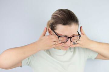 Fototapeta premium young woman rubs tired eyes from glasses, poor eyesight, vision problems.