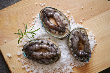 Fresh raw abalone and salt on marble 