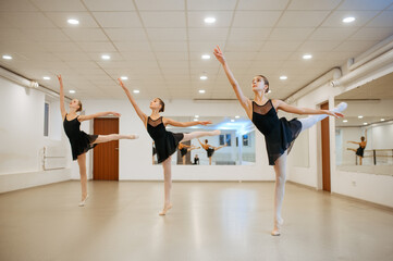 Fototapeta na wymiar Three young ballerinas, teens rehearsing in class