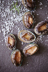 Fresh raw abalone and salt on marble 