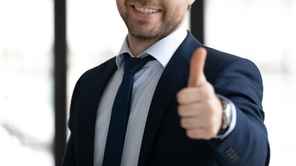 Crop close up of happy male CEO or boss in formalwear show thumb up give recommendation. Smiling...