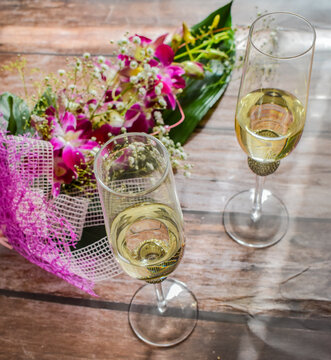 Bouquet of beautiful flowers with glass of champagne. Celebrate concept