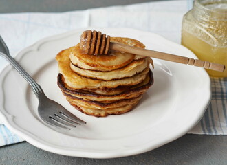 Pancakes with honey on a white plate. Traditional treat for Shrovetide.