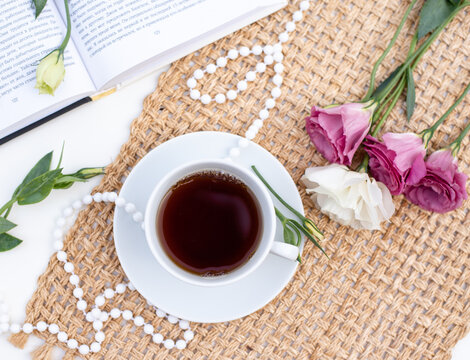 Magic mood atmosphere of love picture for post in Instagram. Take break, rest with tea and book, decoration, by flowers and beads on brown napkin. Learning is development. Layout.