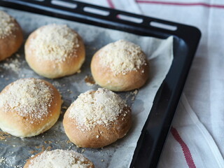 Homemade buns on a black baking sheet from the oven. Ready to eat.Home cooking concept. Bread and rolls.