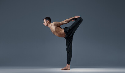 Male yoga keeps balanc in a difficult pose
