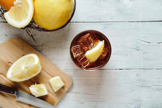 very cold cola on a white background with ice and lemon