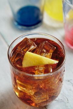 very cold cola on a white background with ice and lemon