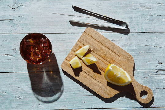 very cold cola on a white background with ice and lemon