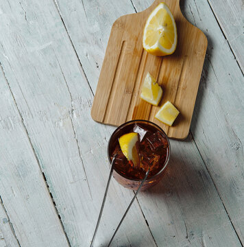 very cold cola on a white background with ice and lemon