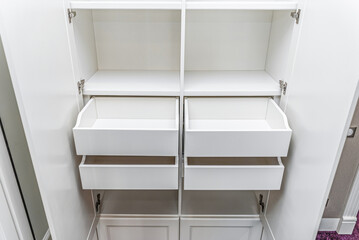 Classical style white wardrobe with inner drawers and empty shelves closeup view