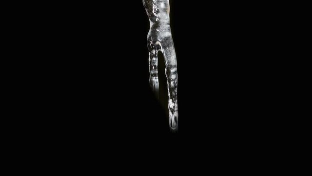 Time lapse sequence of a growing icicle in front of a black background