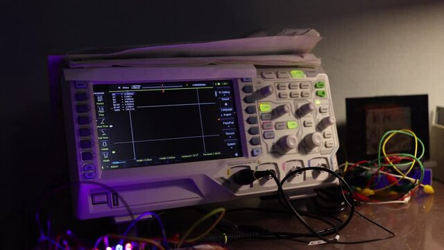 An Oscilloscope In The Workplace. Different Amplitudes Of Waveforms On The Oscilloscope Screen. Zoom In Dolly Slider Shot.