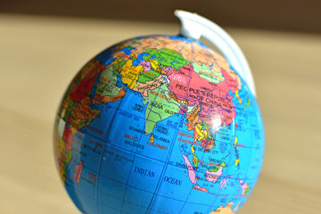 Closeup of small globe focused on India, Pakistan, Nepal, Sri Lanka, Maldive, Indian ocean, blurred background